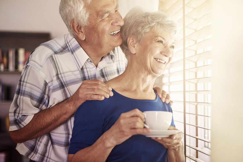 Couple senior regarde par la fenetre